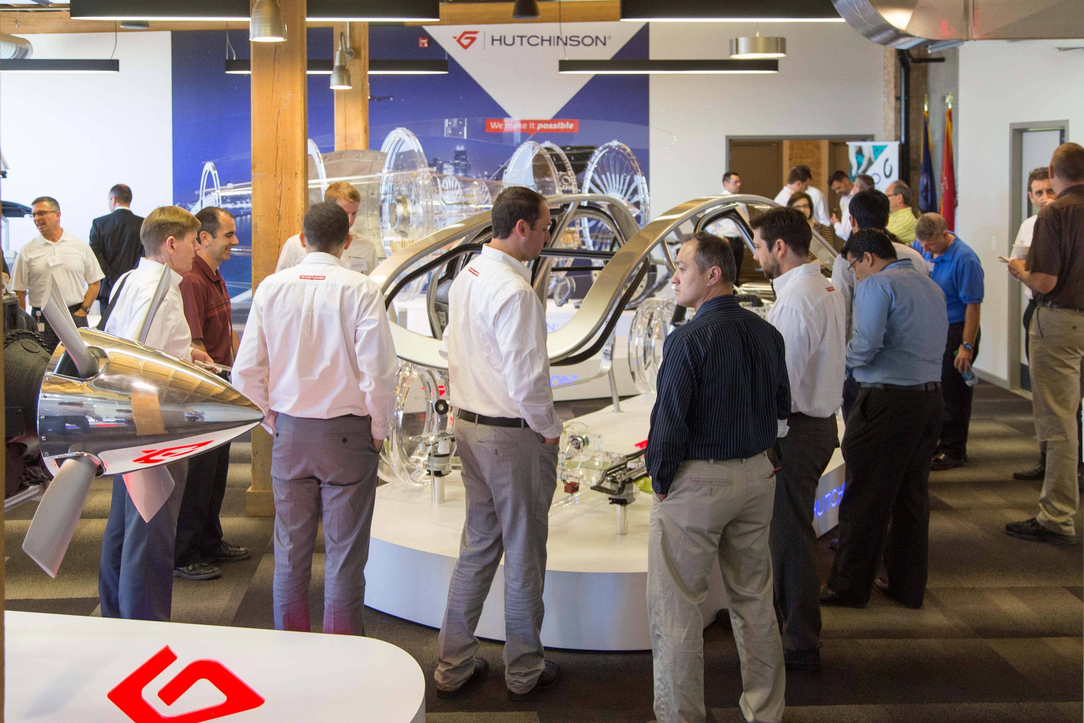 Photo of employees and partners viewing translucent car models in Hutchinson's 616 Fab House